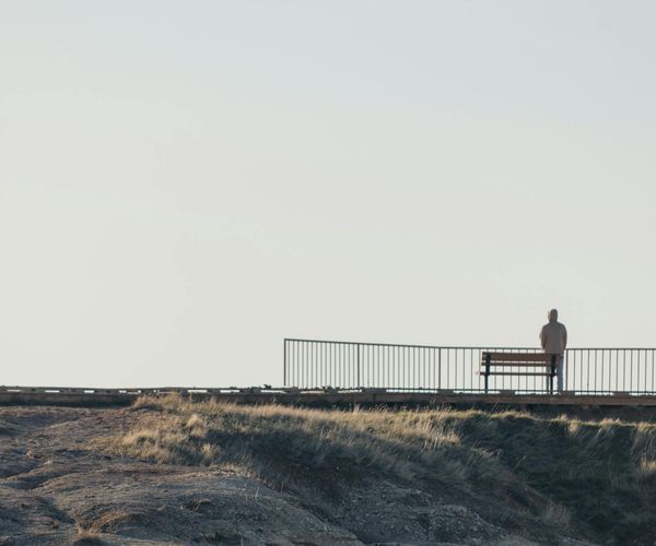 Silhouette of a person meditating in front of a calm background.